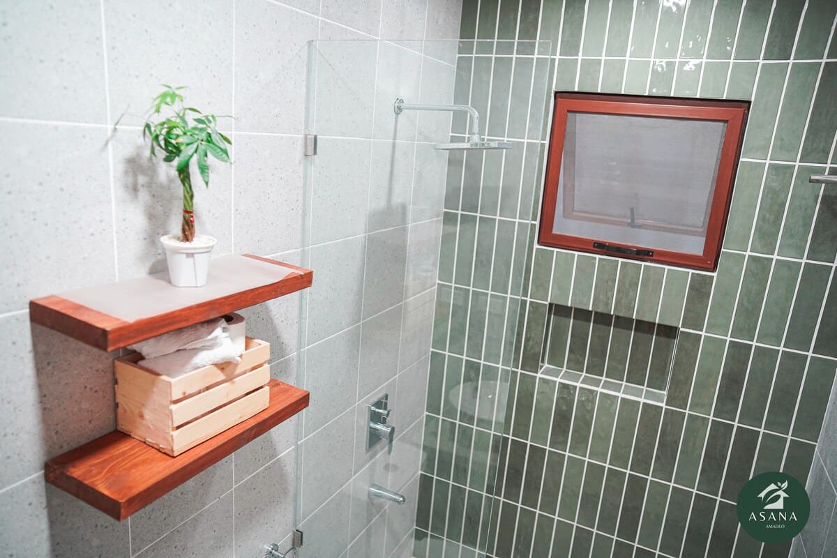 Bathroom shelf with towels, plant, and shower fixtures