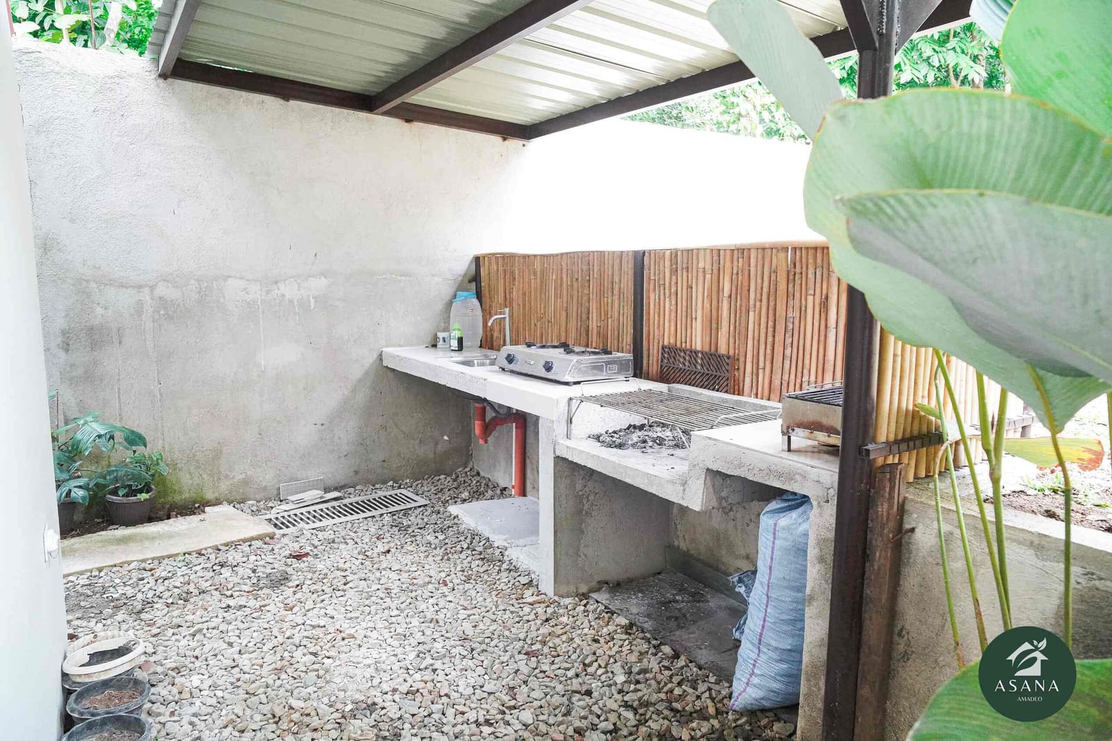 Outdoor grilling station with a concrete counter, gas burner, and charcoal grill