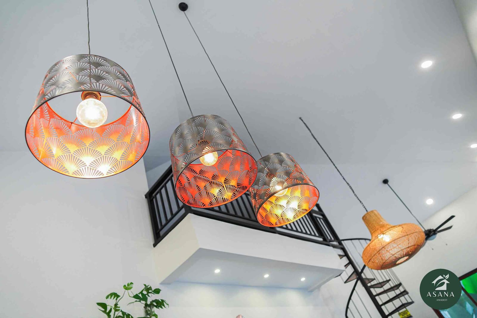 Patterned pendant lights above the kitchen island, loft railing behind
