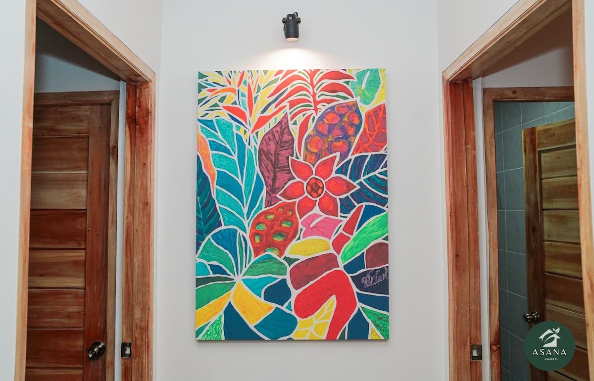 Colorful framed artwork in the hallway between two doors