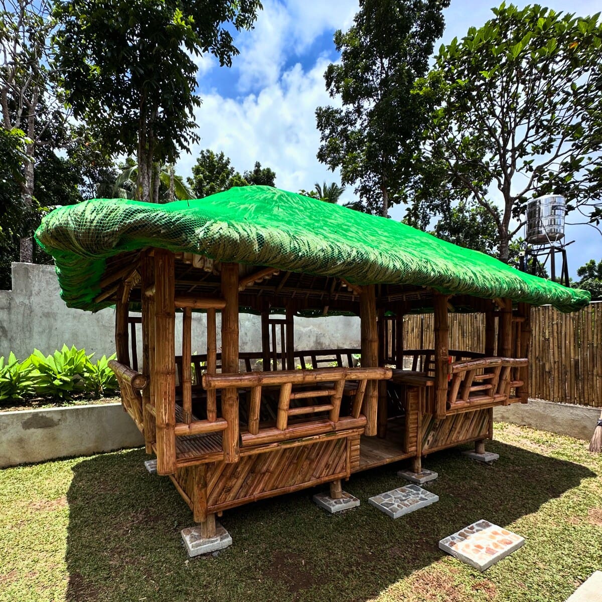 Bamboo kubo with a woven green roof in the garden